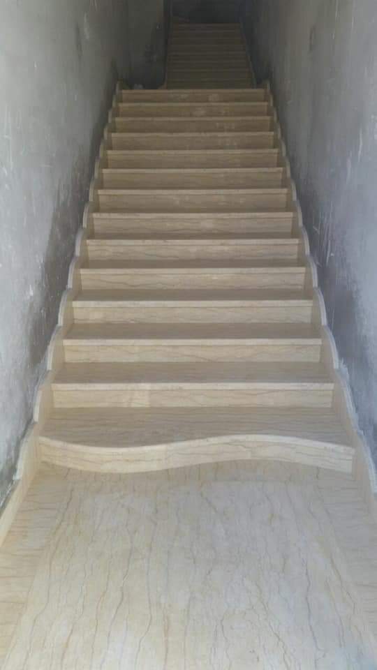 Escalier droit en pierre claire à première marche galbée