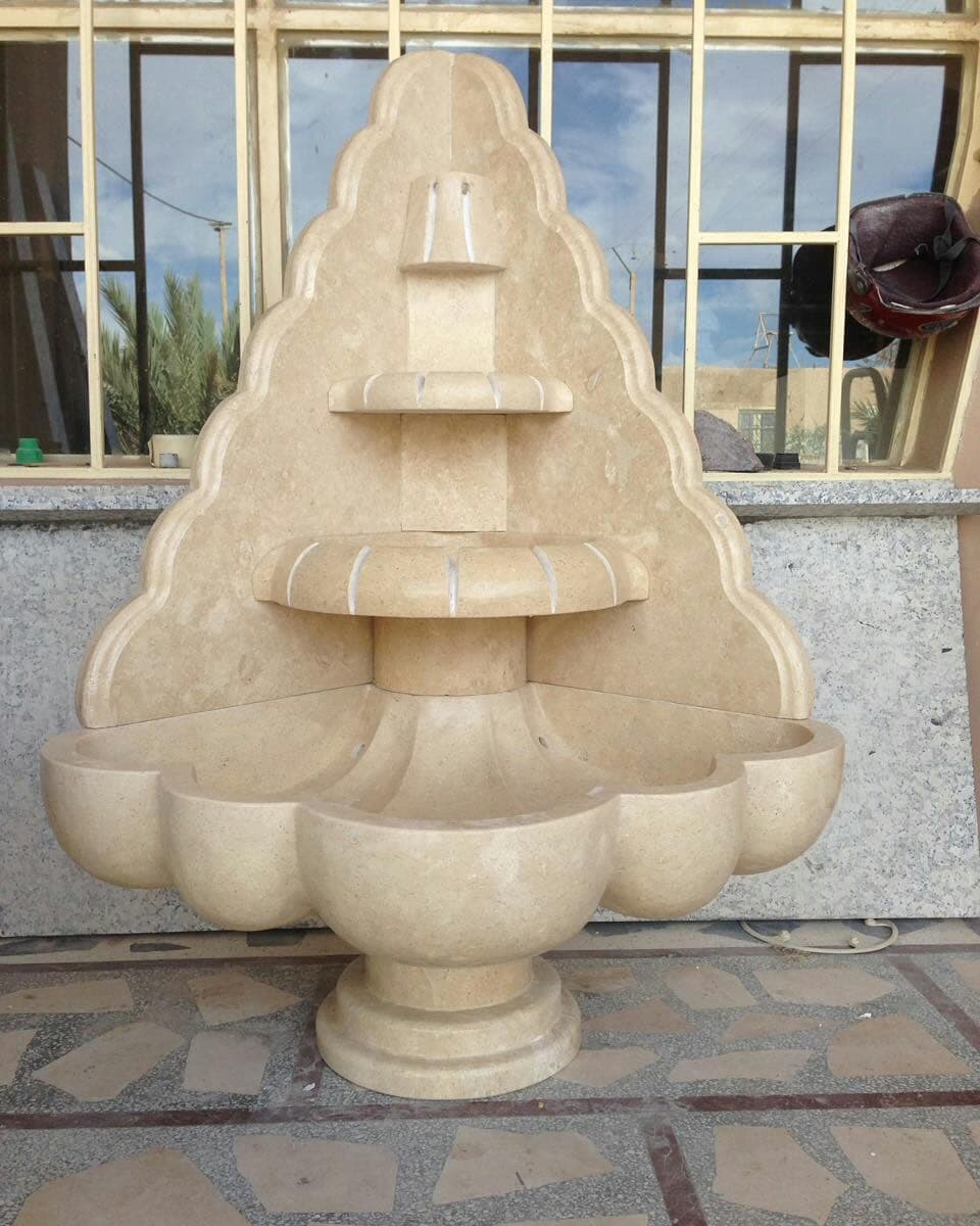 Fontaine murale en pierre claire à trois vasques étagées